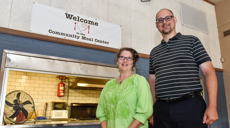 Lauren Marsh, director and president of Community Meal Center, stands with Joe Schrock, pastor of Zion Lutheran Church, stands inside Zion Lutheran Church that hosts a free dinner on Friday evenings. NICK GRAHAM/STAFF