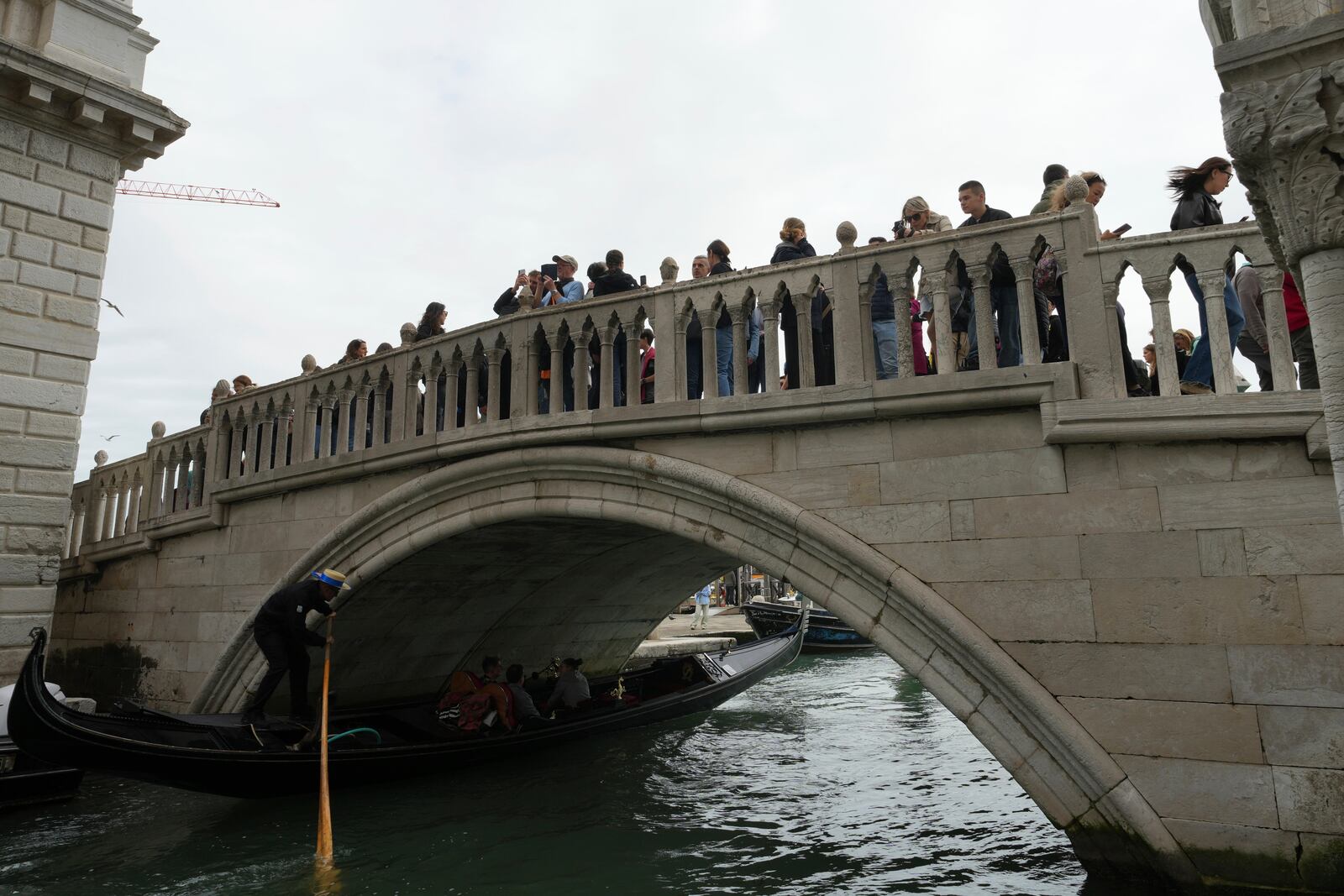 Tourists take pictures in San Marco square in Venice, Italy, Friday, April 18, 2025, Venice on Friday launches for a second year a pilot program to charge day-trippers an entrance fee. (AP Photo/Antonio Calanni)