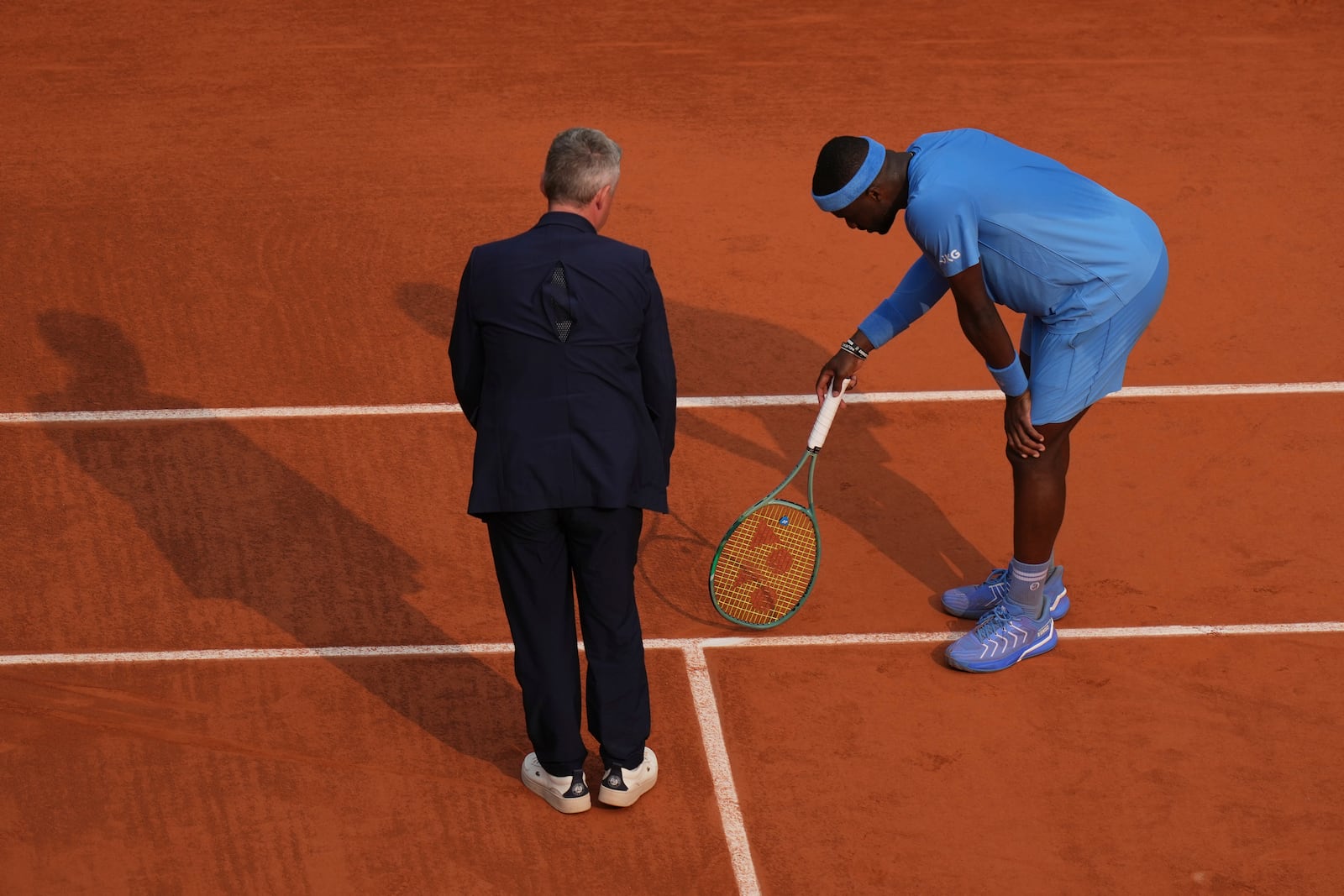 United States' Frances Tiafoe and the chair umpire check the mark on the clay as he plays against Italy's Lorenzo Musetti during their quarterfinal match of the French Tennis Open at the Roland-Garros stadium in Paris, Tuesday, June 3, 2025. (AP Photo/Thibault Camus)