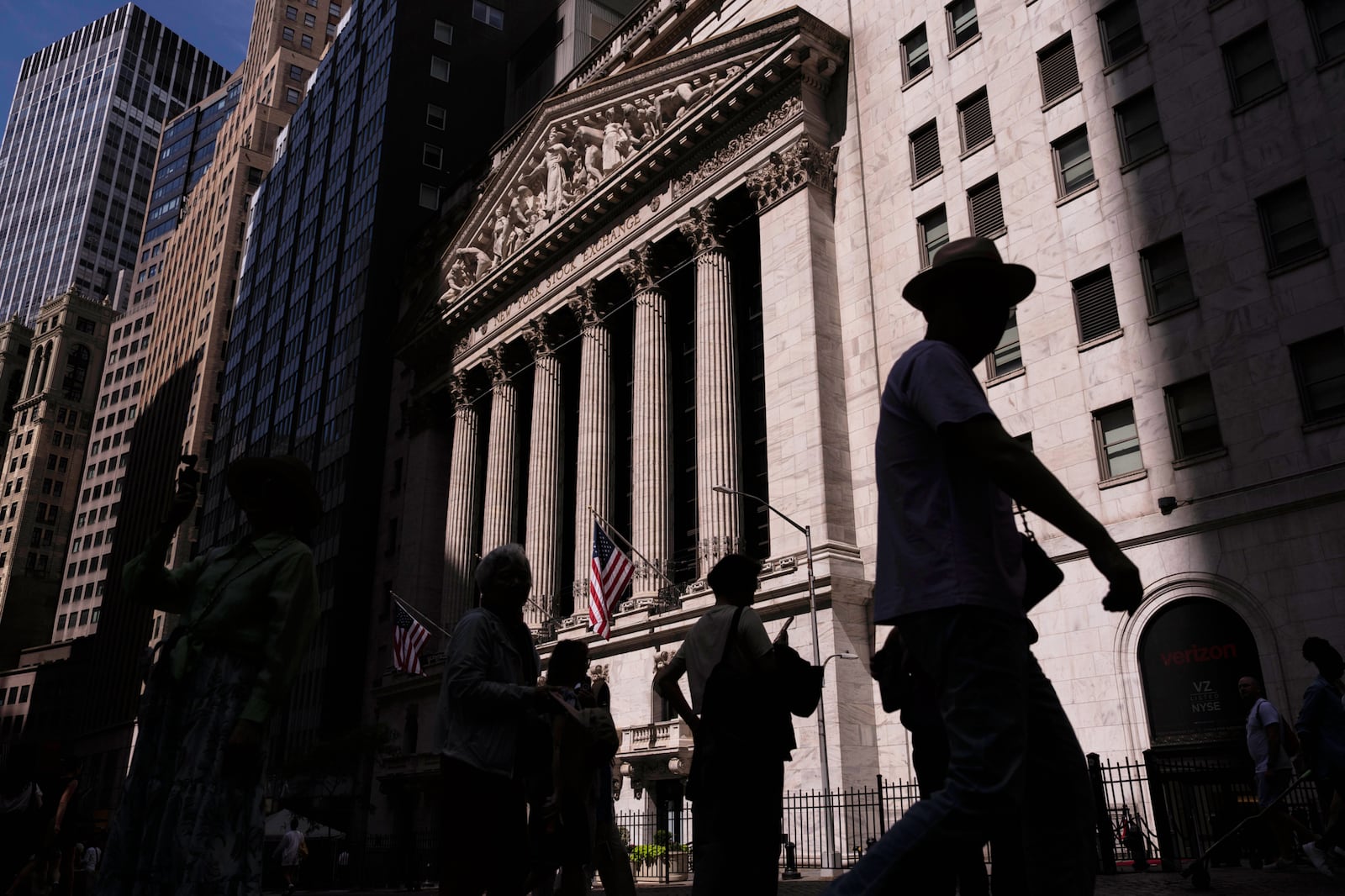 People walk past the New York Stock Exchange on Monday, June 30, 2025, in New York. (AP Photo/Yuki Iwamura)