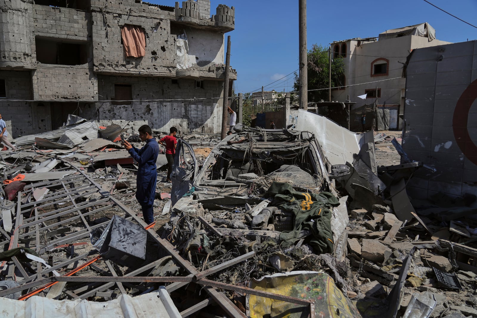 Palestinians inspect the wreckage of a gas station destroyed in an Israeli airstrike in Deir al-Balah, central Gaza Strip, Saturday, July 12, 2025. (AP Photo/Abdel Kareem Hana)