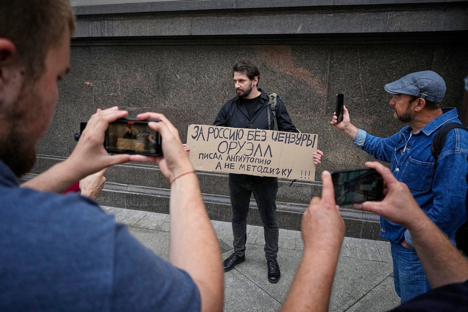 An activist holds a poster reading "For Russia without censorship. Orwell wrote a dystopia, not an instruction manual" during a picket against internet limitations in front of The State Duma, the lower house of the Russian Parliament, prior to consider the third and final reading of a bill, criminalising the search of "extremist materials" in Moscow, Russia, Tuesday, July 22, 2025. (AP Photo)