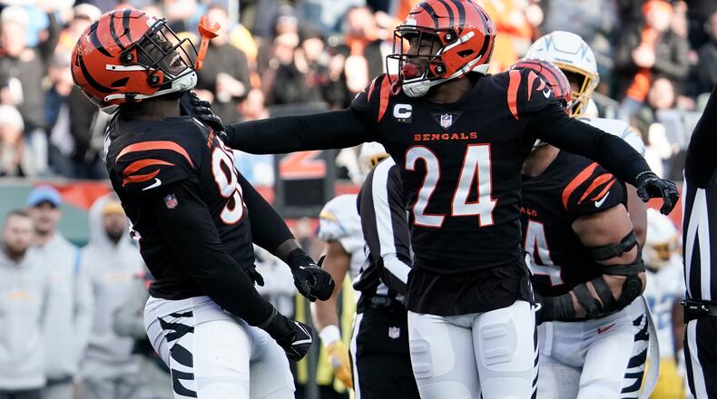 Cincinnati Bengals' Cameron Sample (96) and Vonn Bell (24) celebrate a sack of Los Angeles Chargers' Justin Herbert during the second half of an NFL football game, Sunday, Dec. 5, 2021, in Cincinnati. (AP Photo/Jeff Dean)