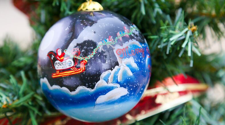 This year’s installment of the Hamilton Police Department ornament features Santa’s sleigh pulled by miniature horses from Seven Oaks Farm in Ross Twp. The horses have attended many community events with police officers throughout the year, opening up lines of communication with children and adults, officials said. GREG LYNCH / STAFF
