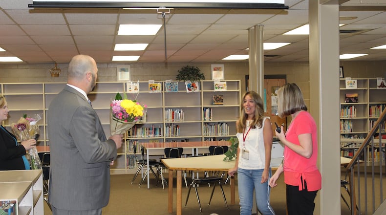 Audrey Young, counselor for Freedom Elementary, is surprised with flowers and news delivered by Principal Lance Green on her winning Lakota s annual Educators of Excellence award for grades pre-K through 6th.