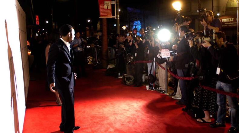 Springfield native John Legend poses for a wall of photographers as he walks down the red carpet to the Sony party in Hollywood after winning three Grammy Awards in 2006. MARSHALL GORBY / STAFF