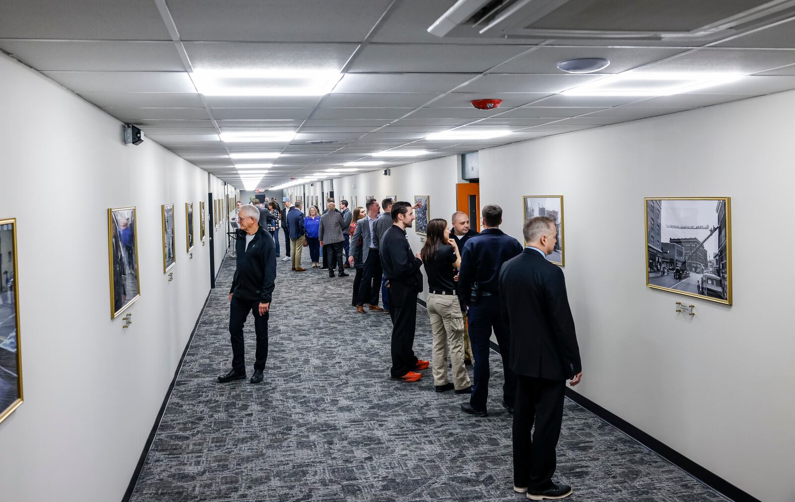 Those who attended the grand opening of Berachah Church's Compassion City Center Friday morning look over the 35 historic and recent photos of Middletown that line one hallway. Friday. NICK GRAHAM/STAFF