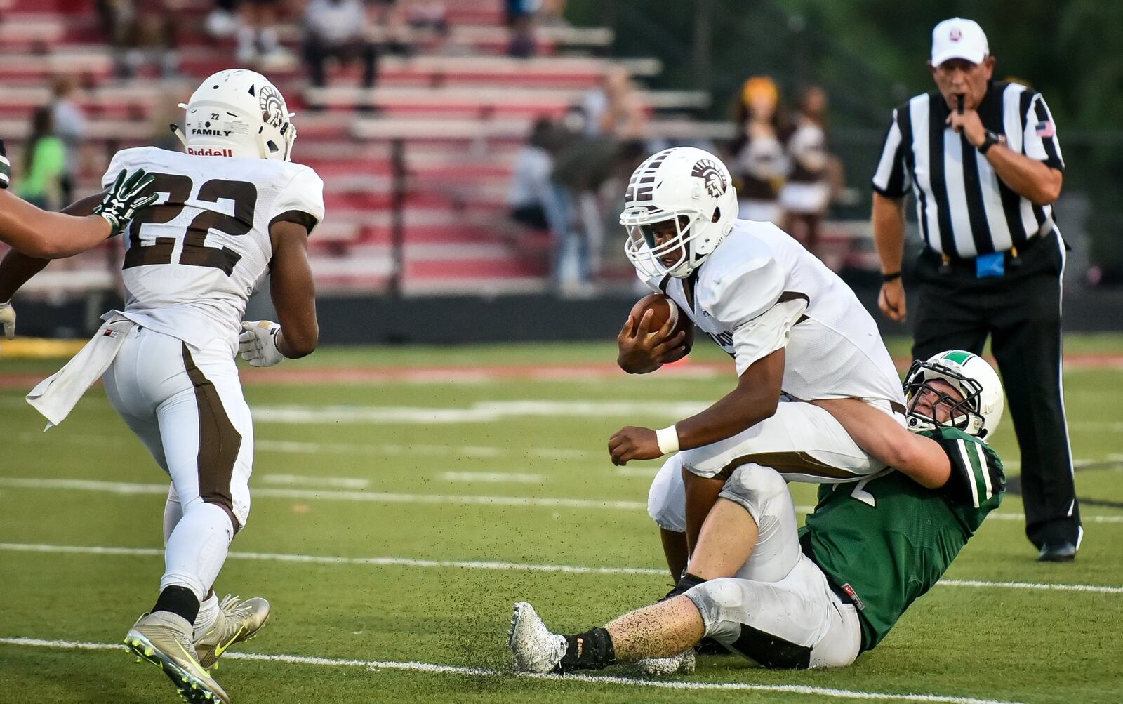 Badin’s Bryce Holian sacks Roger Bacon quarterback Tyler Bullock during their game Friday night at Fairfield Stadium. NICK GRAHAM/STAFF