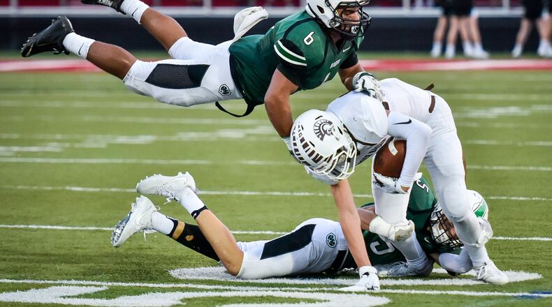 Badin’s Lavassa Martin (6) and Marshall Flaig (5) tackle Roger Bacon’s Zak Cappel during their game Sept. 22, 2017, at Fairfield Stadium. The host Rams won 41-21. NICK GRAHAM/STAFF