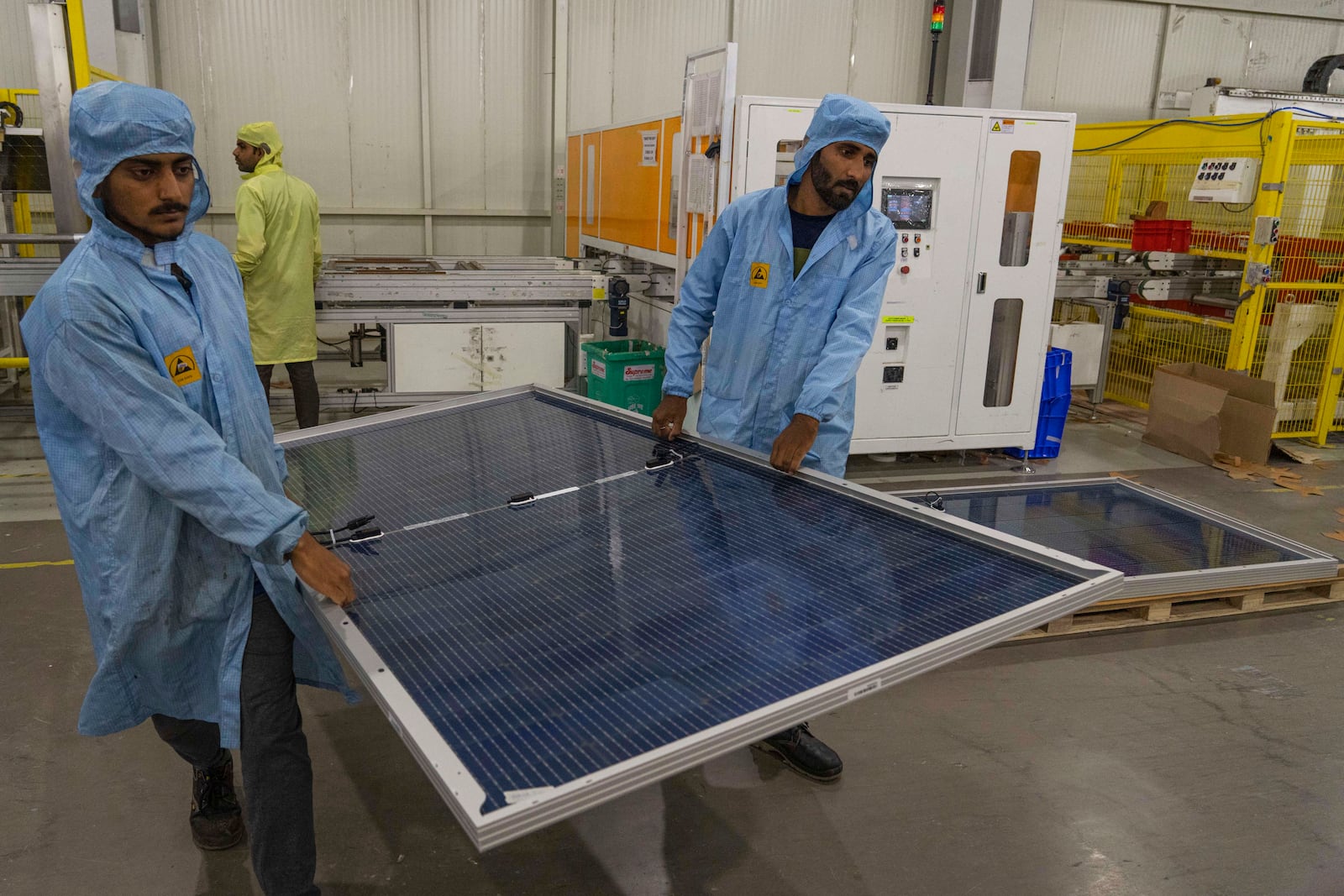FILE - Employees carry solar panels at the Adani New Industries Limited in the port town of Mundra in Western India's Gujarat state, India, Sept. 20, 2023. (AP Photo/Rafiq Maqbool, File)