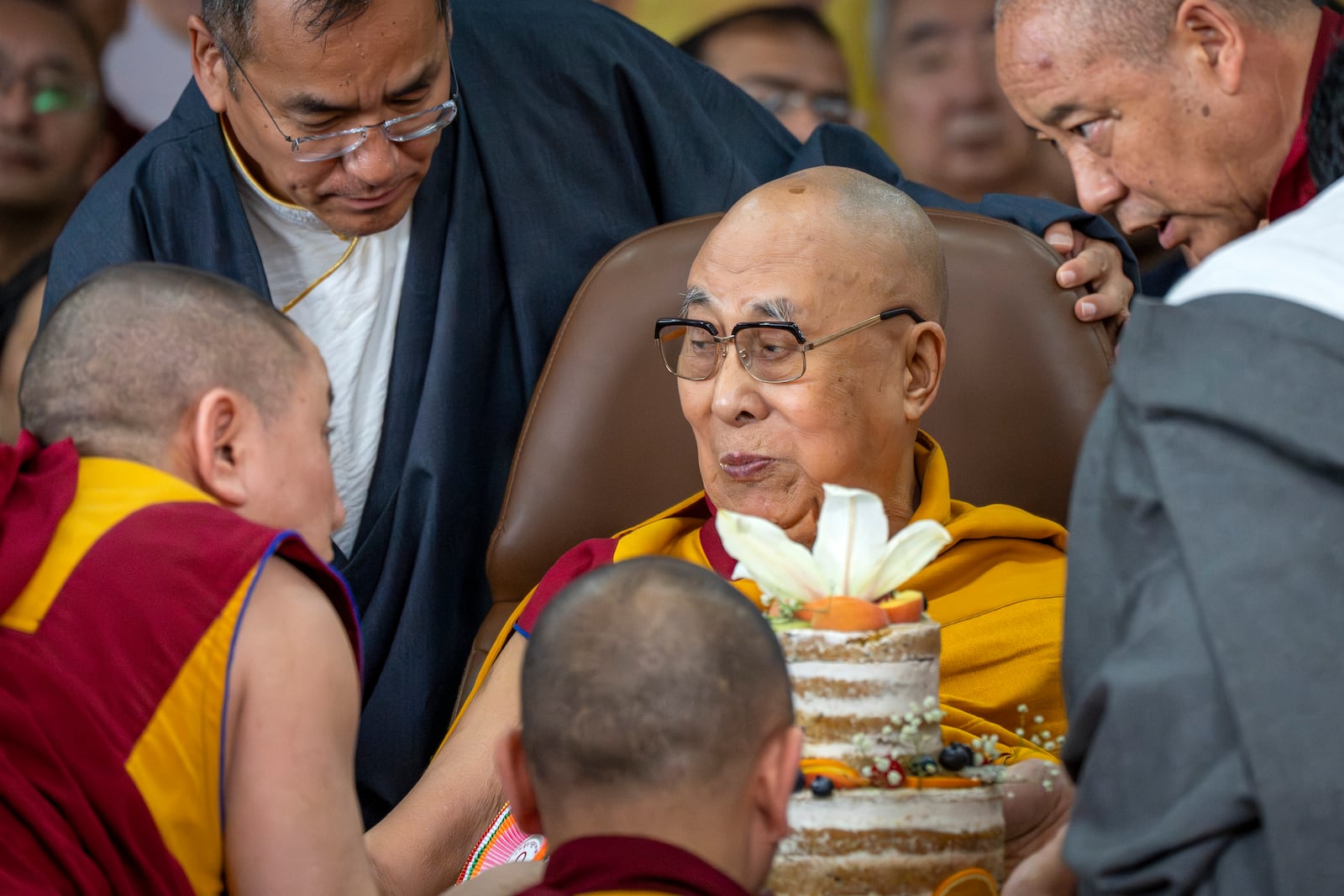 Tibetan spiritual leader the Dalai Lama eats a cake during his 90th birthday celebrations at the Tsuglakhang temple in Dharamshala, India, Sunday, July 6, 2025.(AP Photo/Ashwini Bhatia)