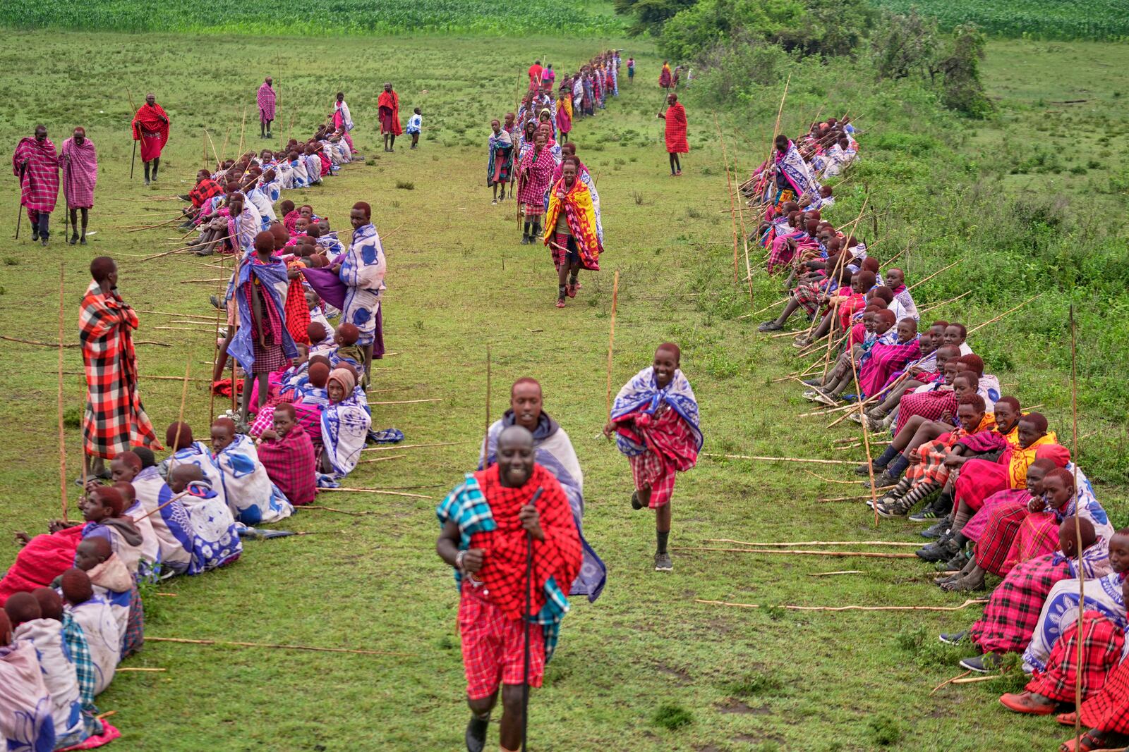 Children of the Maasai tribe gather on an open field, during the Enkipaata ceremony, a Maasai male rite of passage, specifically the initiation of boys, marking the transition from childhood to becoming a moran (warrior) in Olaimutiai, Narok County, Kenya Thursday, April 24, 2024. (AP Photo/Brian Inganga)