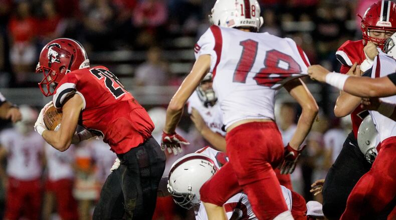 Madison’s Jake Phelps carries the ball during a 54-0 win over visiting Carlisle last Friday night at Brandenburg Field in Madison Township. NICK GRAHAM/STAFF