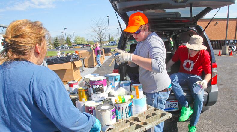 Volunteers at a previous Spring Clean Up Day in Fairfield Twp. help a resident dispose of old paint. STAFF FILE PHOTO