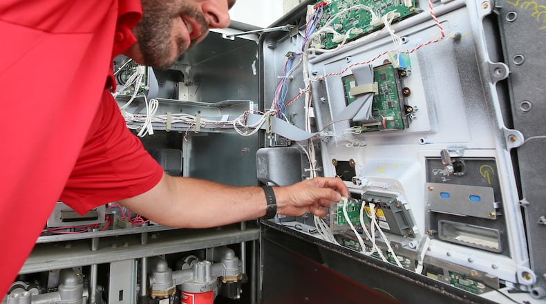 In this 2016 file photo, Tom Kamphaus of the Butler County Auditor’s Office examines the inside of a gas pump at a Shell station in West Chester Twp. GREG LYNCH/2016