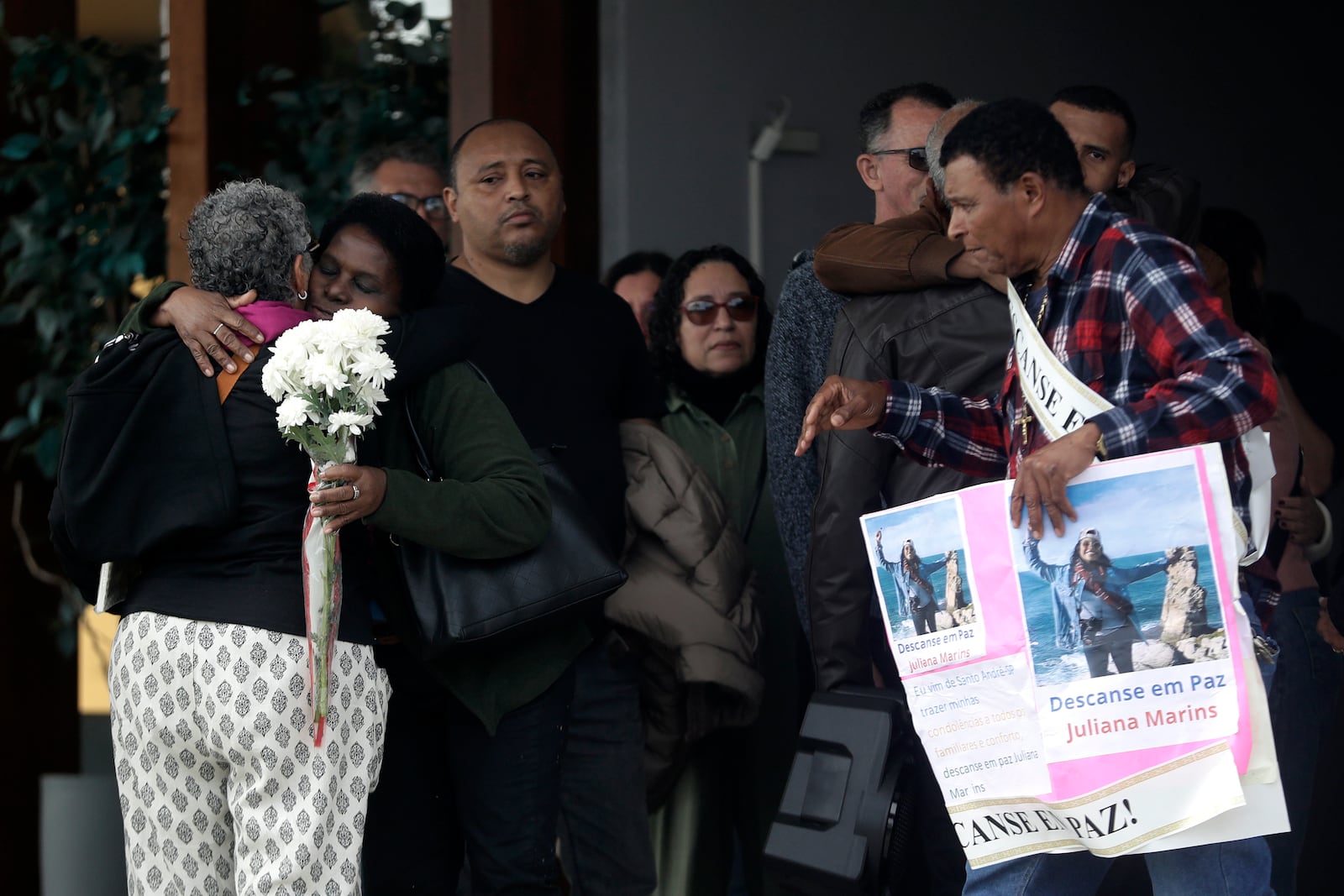 Estela Marins, back to camera, attends the funeral of her daughter Juliana Marins, who died after falling from the summit of Mount Rinjani in Indonesia, at Parque da Colina cemetery in Niteroi, Rio de Janeiro state, Brazil, Friday, July 4, 2025. (AP Photo/Bruna Prado)