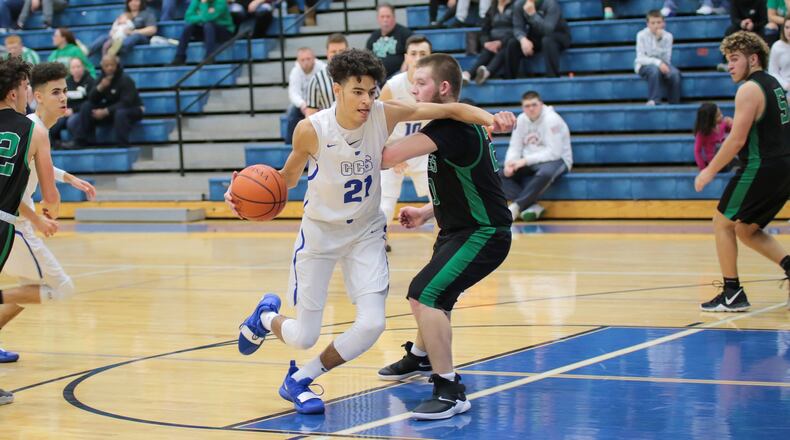 Cincinnati Christian’s Jalon Percy (21) drives around New Miami’s Ronnie Bowman during Tuesday night’s game at CCS. The host Cougars won 54-37. PHOTO BY KRAE/WWW.KRAEPHOTOGRAPHY.COM