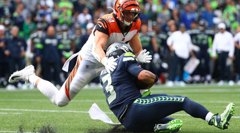 SEATTLE, WASHINGTON - SEPTEMBER 08: Russell Wilson #3 of the Seattle Seahawks is tackled by Sam Hubbard #94 of the Cincinnati Bengals in the fourth quarter during their game at CenturyLink Field on September 08, 2019 in Seattle, Washington. (Photo by Abbie Parr/Getty Images)