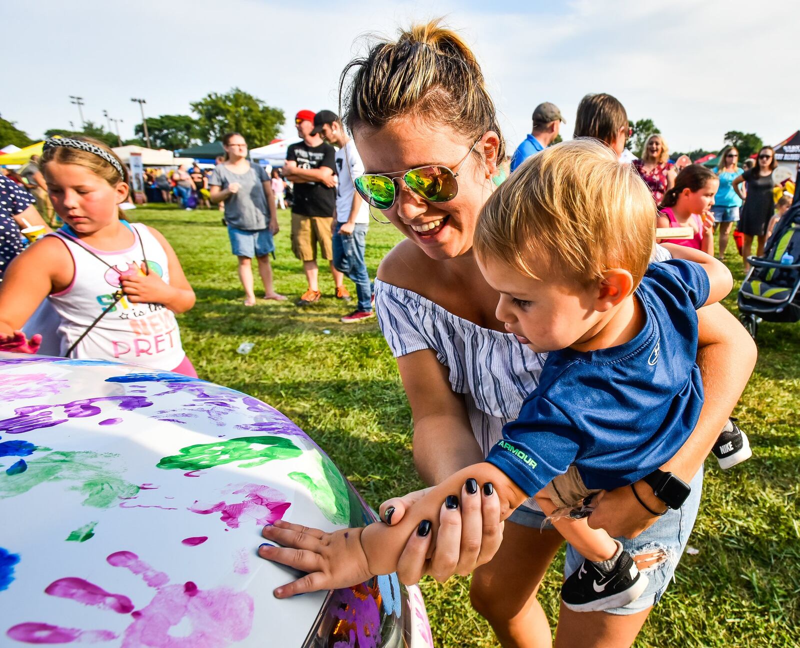 Bethany Harding helps her son Cooper, 1, put a handprint on one of Middletown Division of Police cruisers to show support for the department during Middletown’s National Night Out event last year. 