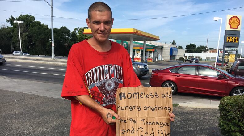 Charles Young holds a sign near the intersection of U.S. 35 and Smithville Road. “I’ve been looking for a job. It’s just been rough. I don’t want to do this. I want to get off the street,” he said.