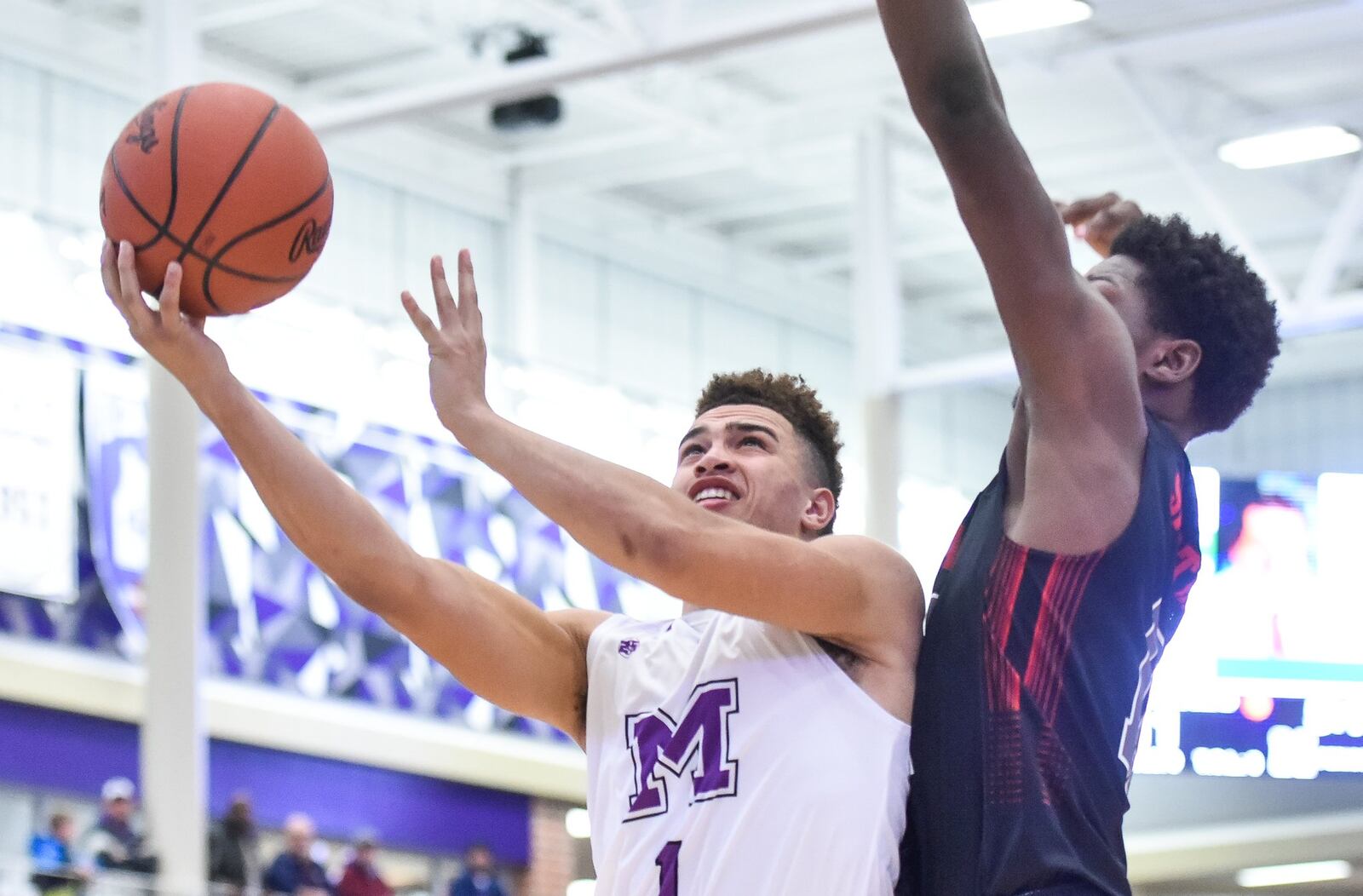 Middletown’s Blake Marshall goes up for a shot as Lima Senior’s Jainaz Cameron defends Saturday night at Wade E. Miller Arena in Middletown. NICK GRAHAM/STAFF