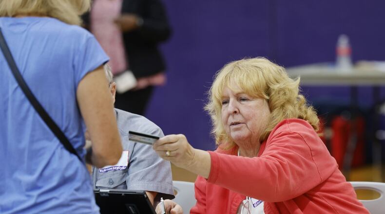 Poll worker Sue Hartness hands a voting card to a voter during the primary election at Highview 6th Grade Center Wednesday, Aug. 2, 2022 in Middletown. NICK GRAHAM/STAFF