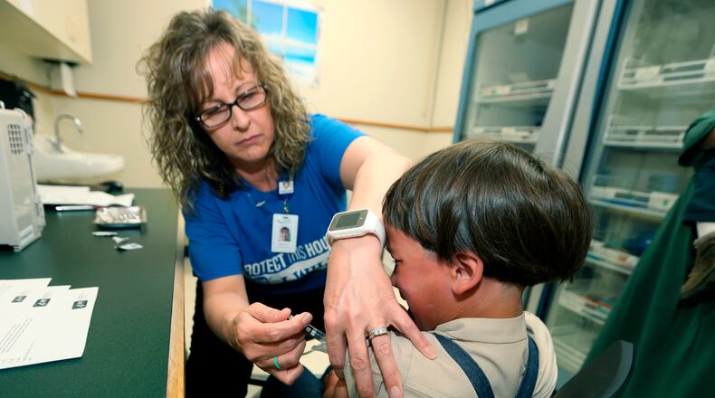A registered nurse with the Knox County Health Department administers a vaccination to a child northeast of Columbus. Last week, the CDC and WHO said a record high of nearly 40 million children missed a measles vaccine dose last year. (AP Photo/Paul Vernon, File)