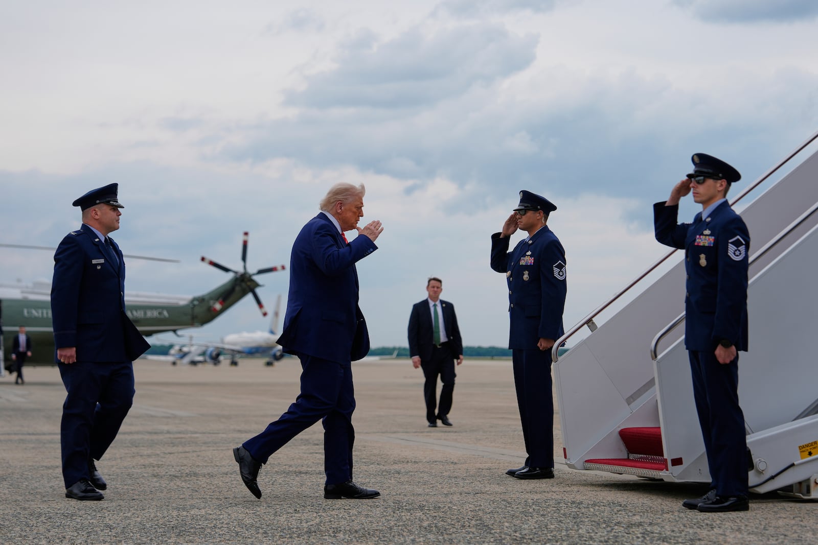 President Donald Trump salutes as he boards Air Force One, Friday, May 30, 2025, at Joint Base Andrews, Md., as Col. Paul Pawluk, Vice Commander of the 89th Airlift Wing, watches at left. (AP Photo/Julia Demaree Nikhinson)