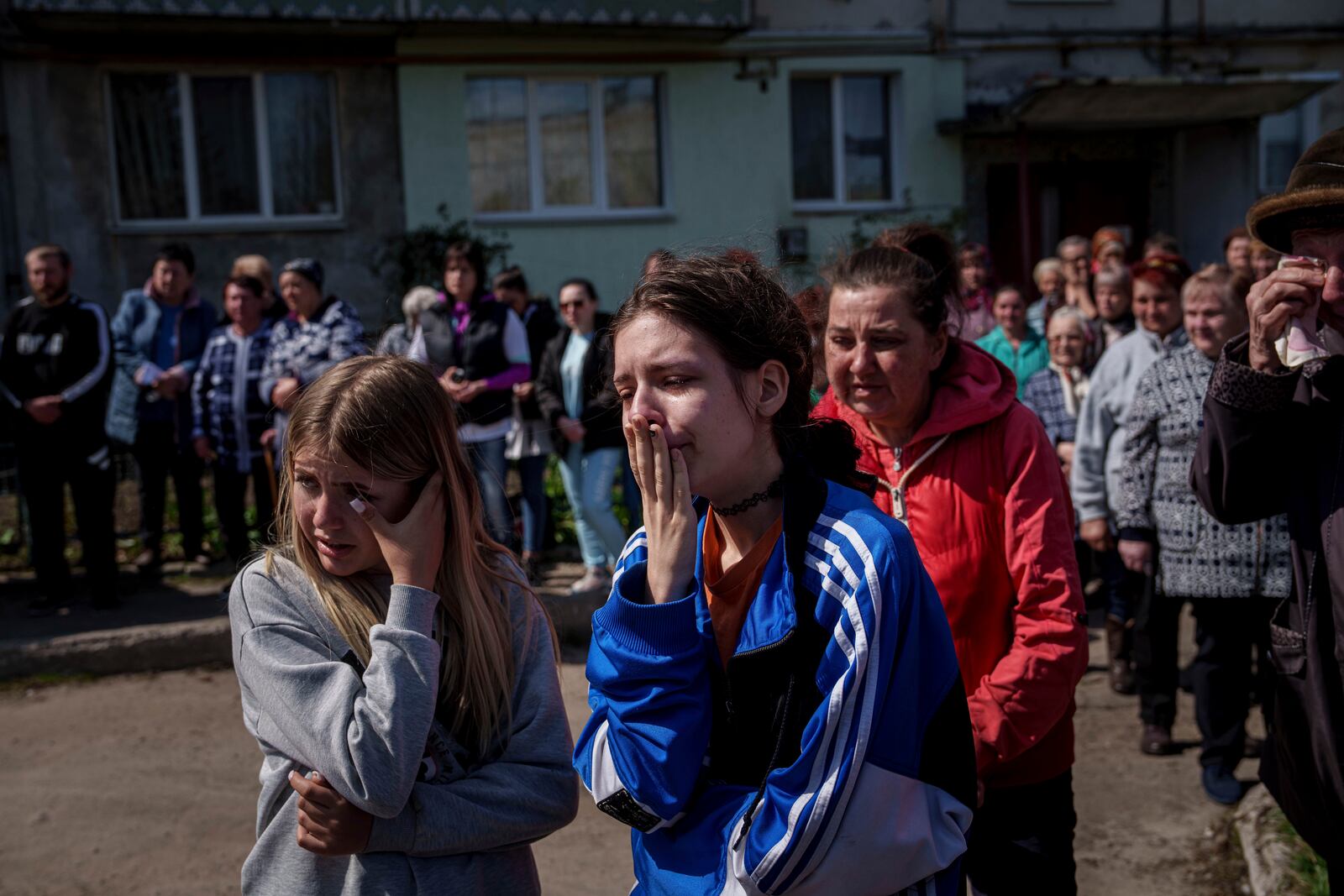 Children cry during farewell ceremony for Maksym Martynenko, 11, Natalia Martynenko, 49, and Mykola Martynenko, 41, killed in a deadly Palm Sunday Russian attack on Sumy on April 13, in Stare Selo village near Sumy, Ukraine, April 16, 2025. (AP Photo/Evgeniy Maloletka)
