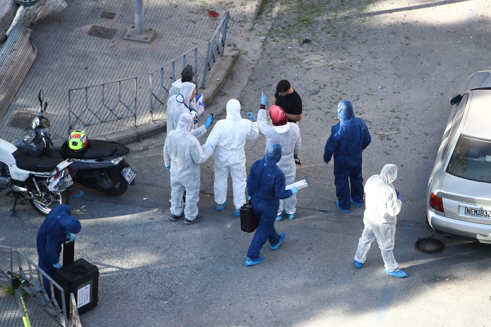 Greek police forensic experts search the area where a 38-year-old woman was killed early Saturday when a bomb she was carrying exploded in her hands outside a bank branch, local police said, in Thessaloniki, northern Greece, May 3, 2025. (AP Photo/Giannis Papanikos)