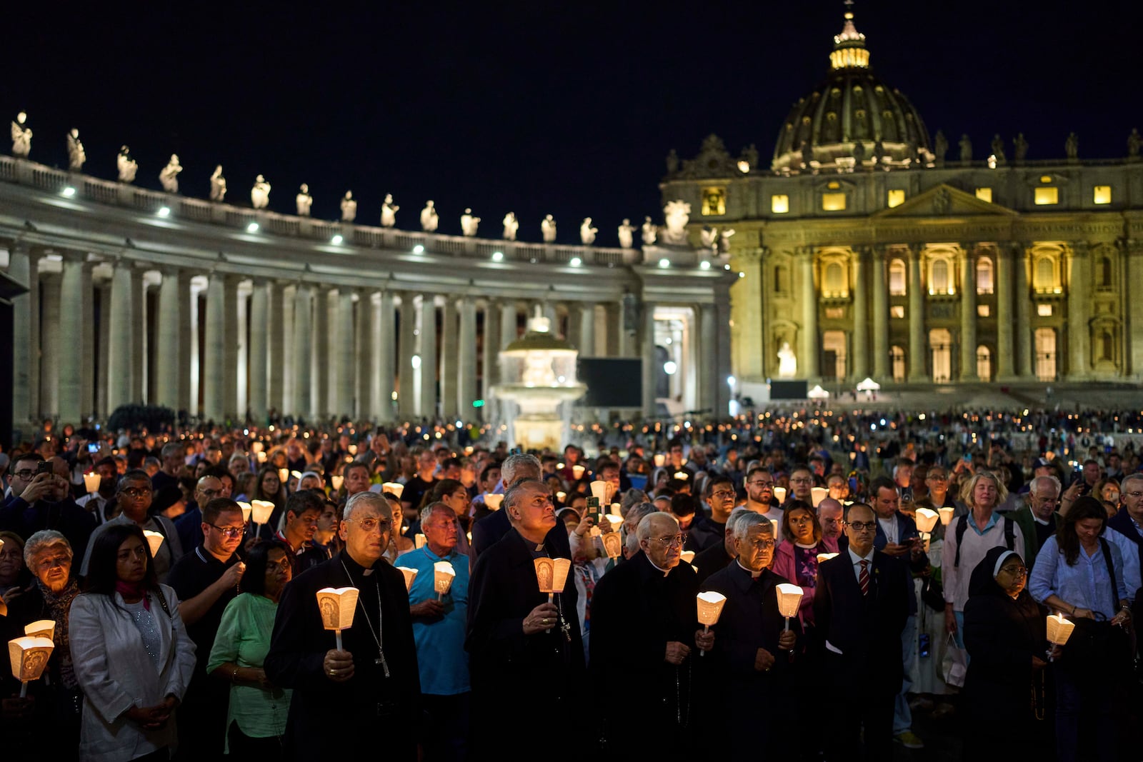 In the foreground center to right: Cardinal Mauro Gambetti, Cardinal Dean Giovanni Battista Re, and Cardinal Lazarus You Heung-sik attend a rosary prayer and a candlelight procession with the image of Mater Ecclesiae in St. Peter's Square at the Vatican, Saturday, May 3, 2025. (AP Photo/Bernat Armangue)