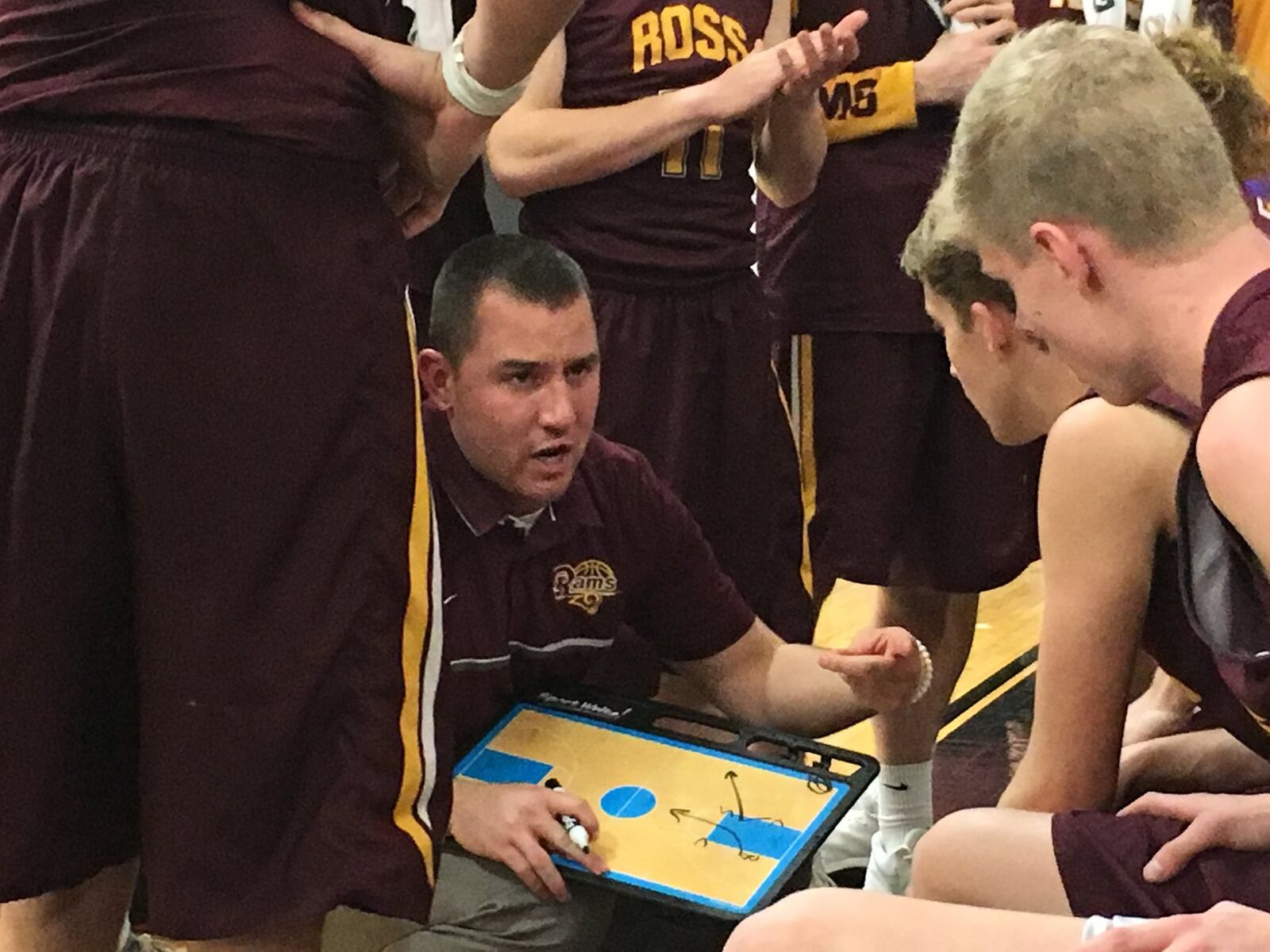 Ross coach David Lane talks in a timeout huddle during Saturday night’s game against Badin at Mulcahey Gym in Hamilton. RICK CASSANO/STAFF