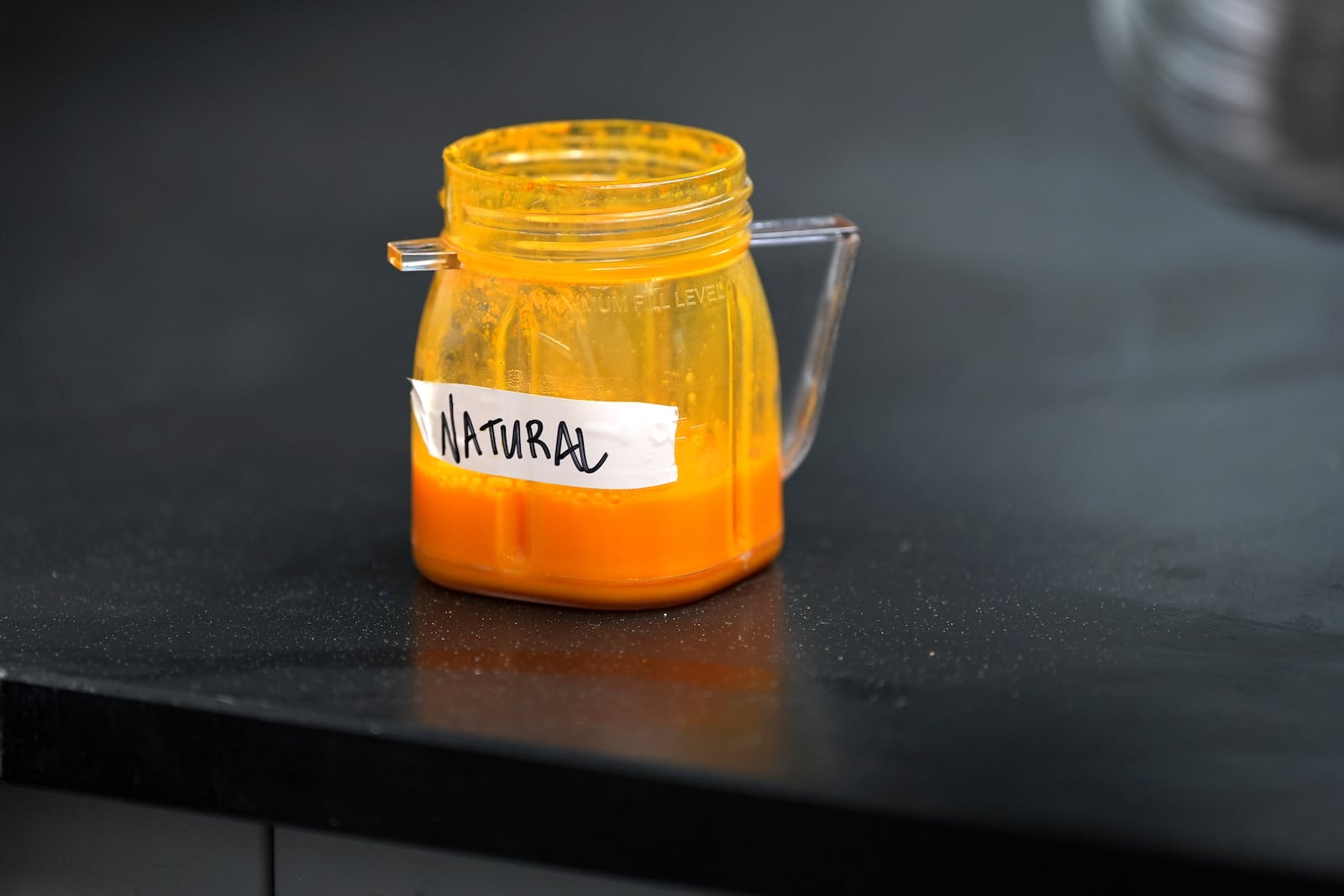 Natural food coloring is held in a jar in a lab at Sensient Technologies Corp., a color additive manufacturing company, in St. Louis., on Wednesday, April 2, 2025. (AP Photo/Jeff Roberson)