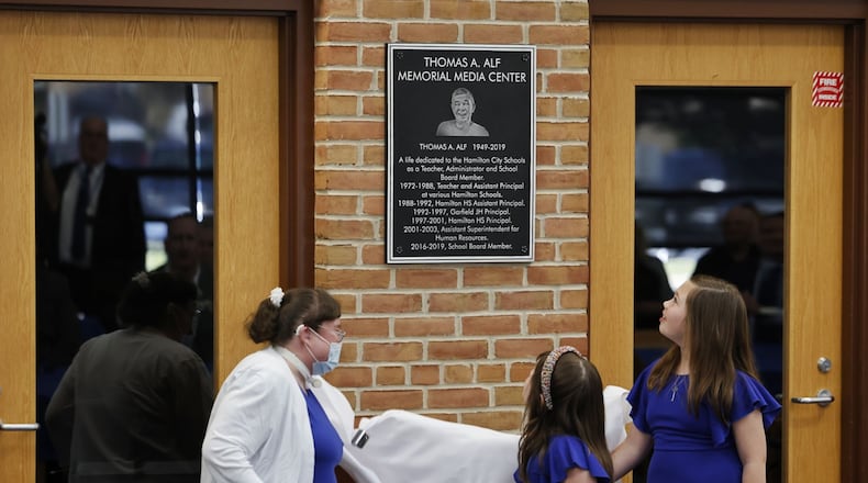 The media center at Hamilton High School was renamed the Thomas A. Alf Memorial Media Center in memory of Alf, who served as teacher, administrator school board member and more for the Hamilton school district. Alf's daughter, Katie Poe, left, and granddaughters Helen Burk, 5, middle, and Ella Burk, 8, unveiled the plaque. NICK GRAHAM/STAFF