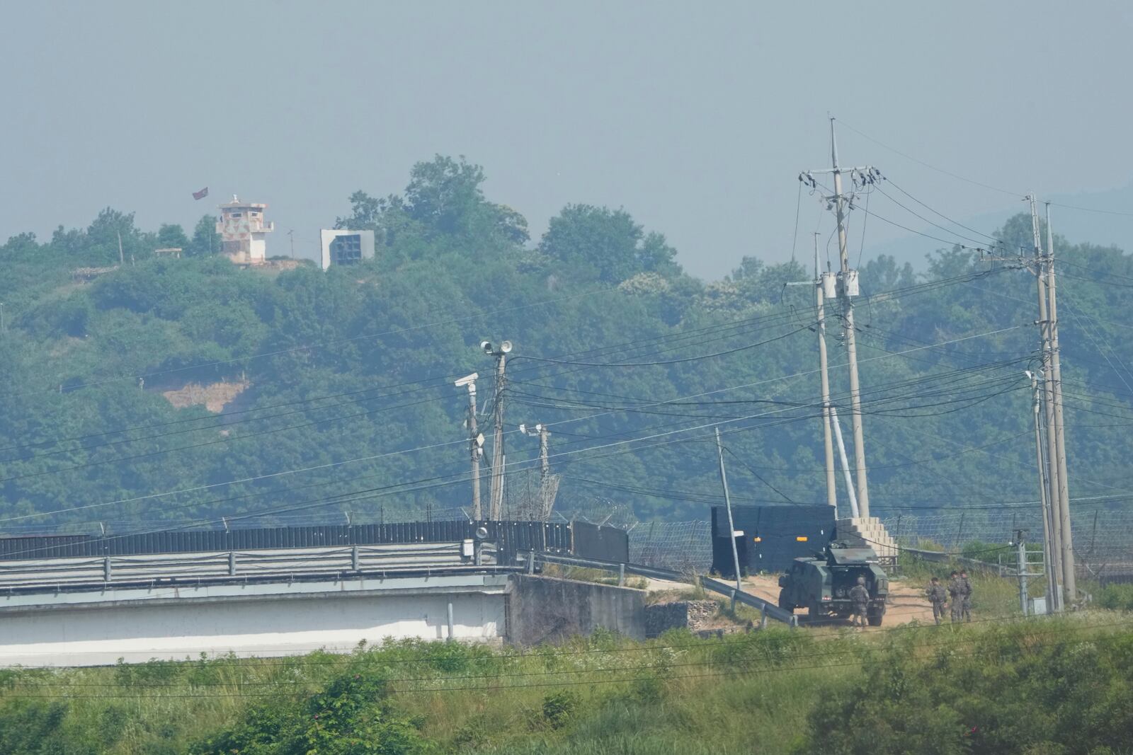 A North Korean military guard post, loudspeaker, top left, and South Korean army soldiers, bottom right, are seen from Paju, South Korea, near the border with North Korea, Thursday, June 12, 2025. (AP Photo/Ahn Young-joon)