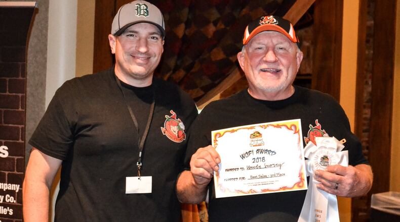 Ryan Stitzel and his father, Greg Stitzel, both of Hamilton, pose with their third place award for Best Salsa at Jungle Jim’s Weekend of Fire Sunday, Oct. 7, 2018. The two men launched their Uncle Snorey business in 2017, offering a Taste Bud Annihilator hot sauce, Jalapeno Relish and Mango Tango Salsa. CONTRIBUTED
