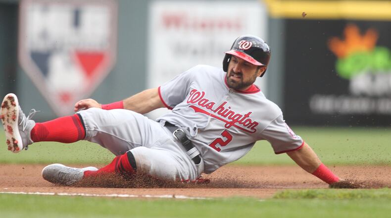 The Nationals’ Adam Eaton slides into third base against the Reds on Opening Day on Friday, March 30, 2018, at Great American Ball Park in Cincinnati. David Jablonski/Staff