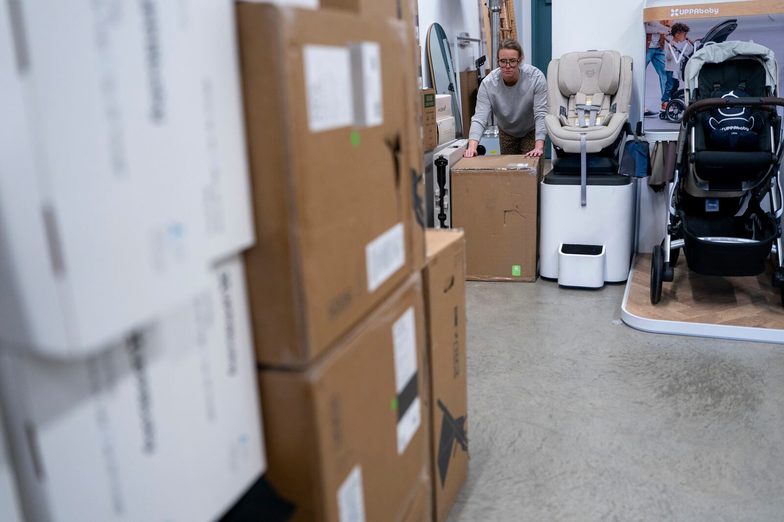 Elizabeth Mahon, owner of the baby store Three Littles, unpacks strollers and other inventory ordered by customers ahead of tariff-driven price increases at her Union Market location in Washington, on Wednesday, April 16, 2025. (AP Photo/Nathan Howard)