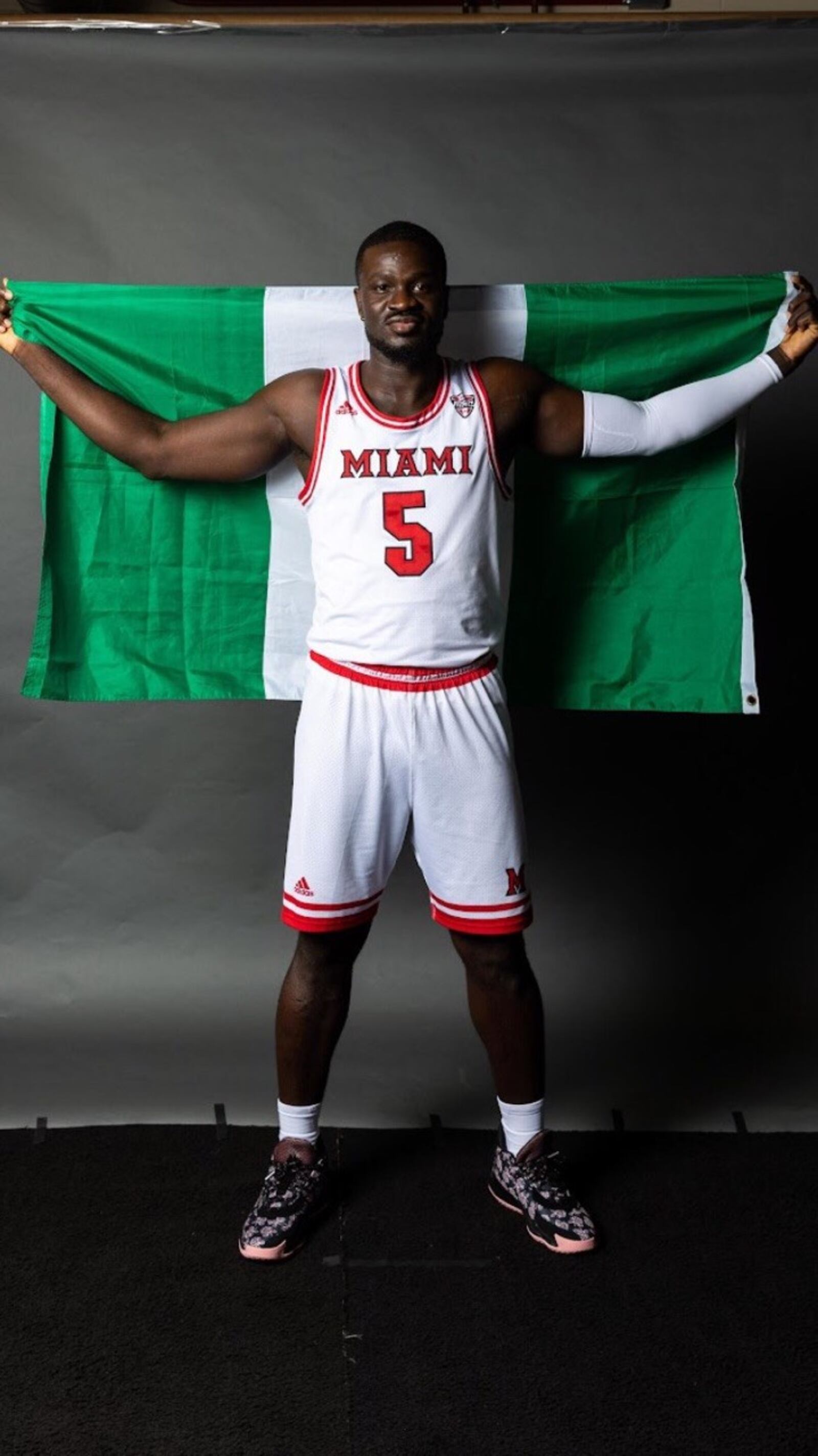 Miami's Precious Ayah with the Nigerian flag.  He grew up in Yenogoa, Nigeria and came to the United States when he was 14 thanks to the Ejike Ugboaja Foundation started by the famed Nigerian basketball player who was drafted by the Cleveland Cavs in 2006 – the only NBA player drafted straight out of Africa—and had a long career with the national team and as a pro for 14 seasons overseas. (Contributed Photo)