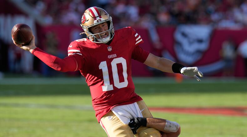 San Francisco 49ers quarterback Mac Jones (10) passes the ball over Tampa Bay Buccaneers linebacker Anthony Nelson, bottom, during the first half of an NFL football game in Tampa, Fla., Sunday, Oct. 12, 2025. (AP Photo/Chris O'Meara)
