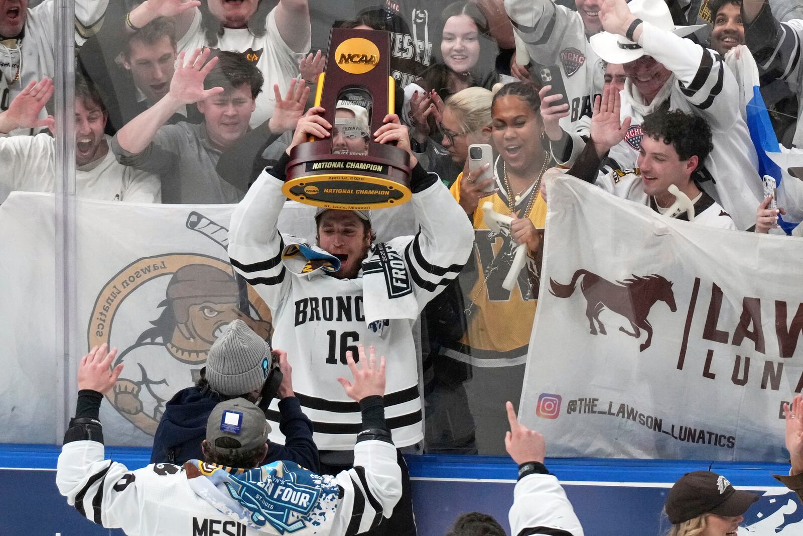 Western Michigan's Tim Washe (16) holds up the trophy while celebrating his team's victory over Boston University in the championship game of the NCAA Frozen Four men's college hockey tournament, Saturday, April 12, 2025, in St. Louis (AP Photo/Jeff Roberson)