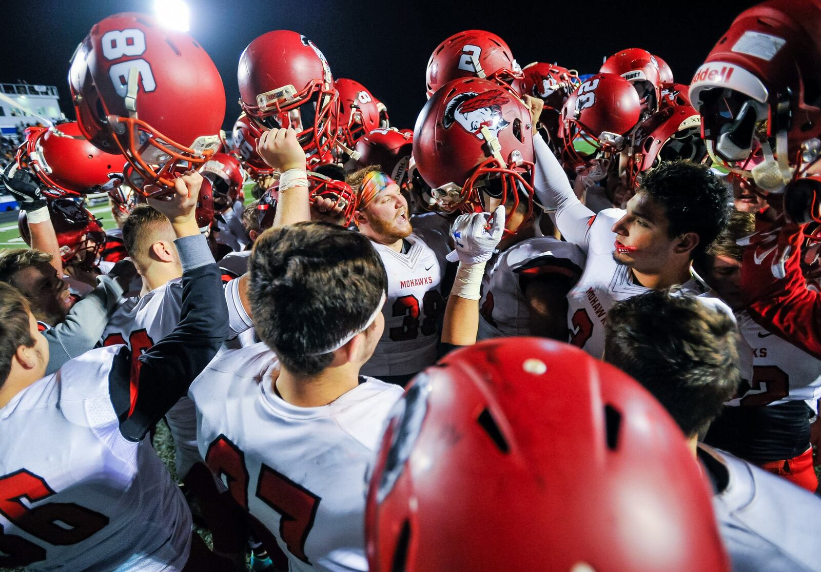Madison players hold their helmets up after their 15-10 loss to Wheelersburg in a Division V state semifinal Friday night at Herrnstein Field in Chillicothe. NICK GRAHAM/STAFF