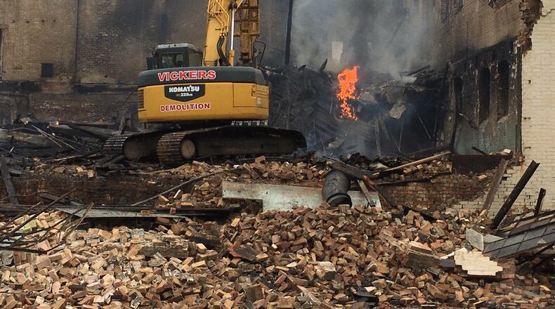 A crew from Vickers Demolition works to move debris and rubble to expose possible hotspots of smouldering fire debris at the Middletown Paperboard facility, 300 S. Verity Parkway in the aftermath of the New Year’s Day fire. The building caught fire after a homeless man built a fire inside the building but left to get more firewood. His bedding caught fire which spread throughout the building. ED RICHTER/STAFF