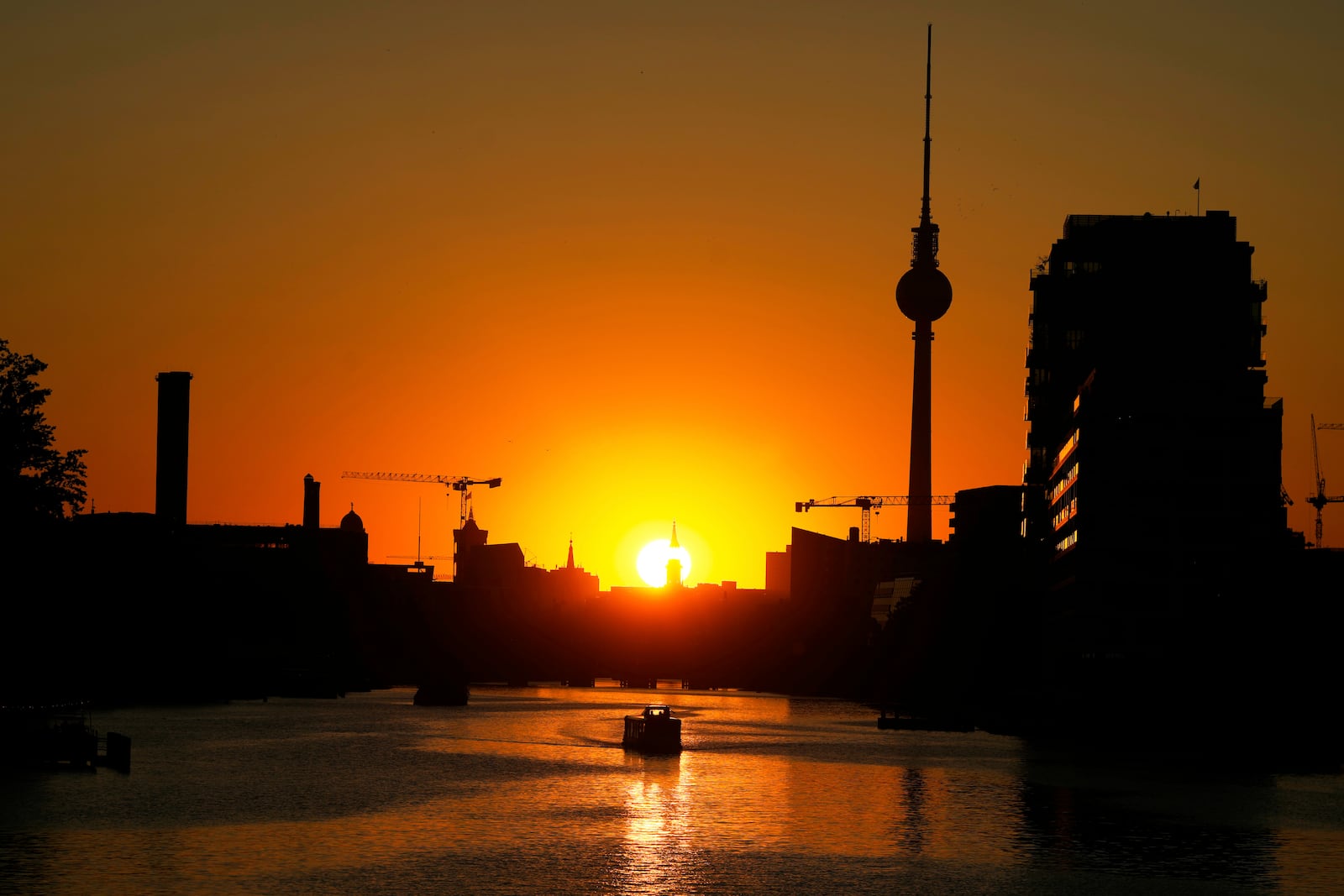 The Television Tower silhouettes in the sunset on a day with hot summer weather in Berlin, Germany, Tuesday, July 1, 2025. (AP Photo/Markus Schreiber)