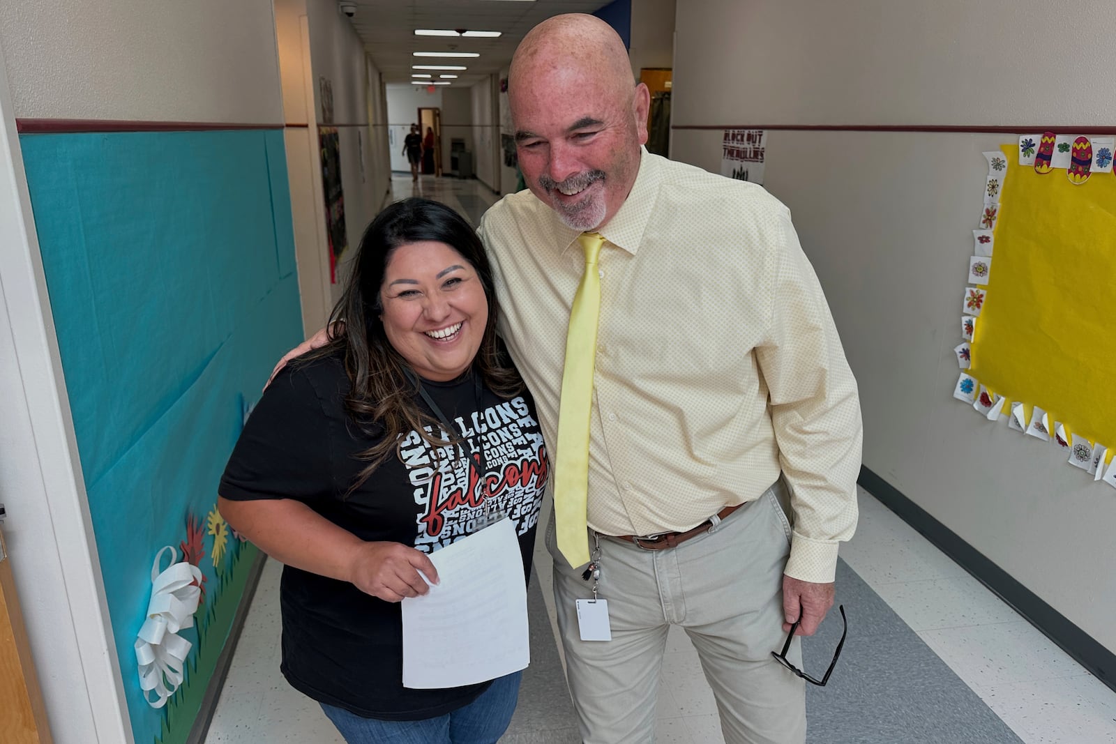 Superintendent Lee White shares a hug with teacher Vanessa Calderon in the hall of the elementary school in Loving, N.M., on Monday, May 19, 2025. (AP Photo/Susan Montoya Bryan)