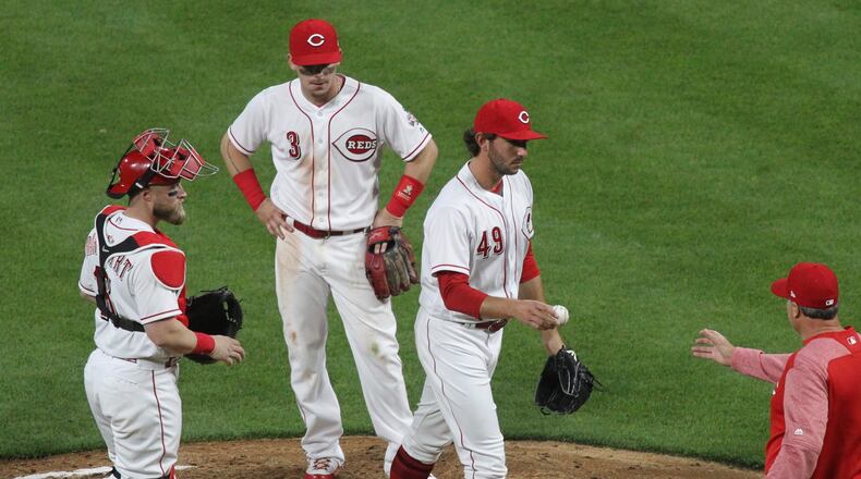 Reds reliever Zack Weiss hands the ball to manager Bryan Price after being removed from the game in the seventh inning on Thursday, April 12, 2018, against the Cardinals at Great American Ball Park in Cincinnati.