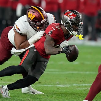 Tampa Bay Buccaneers running back Bucky Irving, right, runs against Washington Commanders defensive tackle Jonathan Allen during the second half of an NFL wild-card playoff football game in Tampa, Fla., Jan. 12, 2025. (AP Photo/Chris O'Meara, file)