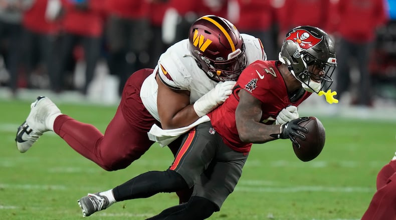 Tampa Bay Buccaneers running back Bucky Irving, right, runs against Washington Commanders defensive tackle Jonathan Allen during the second half of an NFL wild-card playoff football game in Tampa, Fla., Jan. 12, 2025. (AP Photo/Chris O'Meara, file)