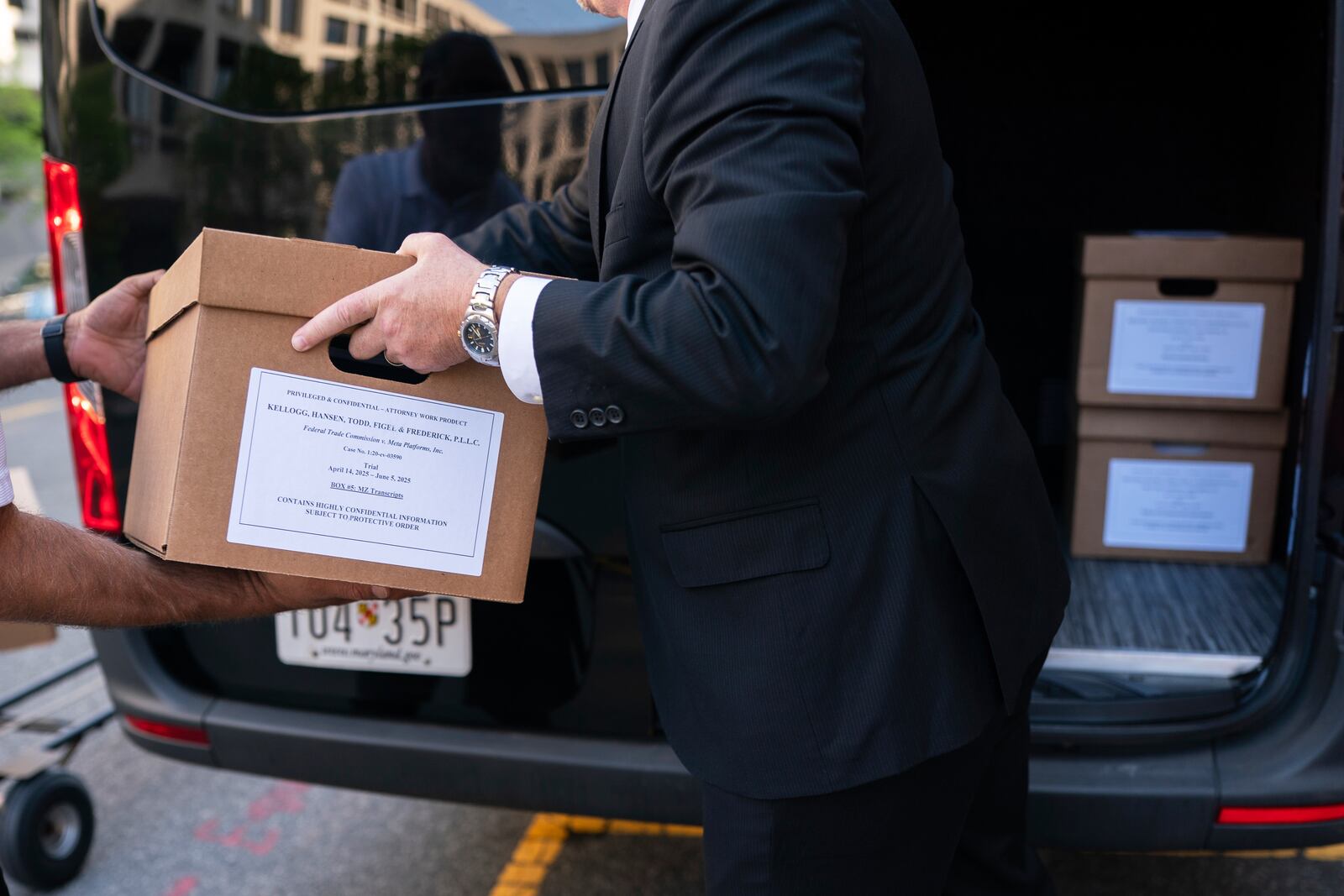 Workers load boxes of documents into a vehicle following the first day of a historic antitrust trial about Meta CEO Mark Zuckerberg's intentions in acquiring Instagram, at Barrett Prettyman United States Court House in Washington, Monday, April 14, 2025. (AP Photo/Nathan Howard)