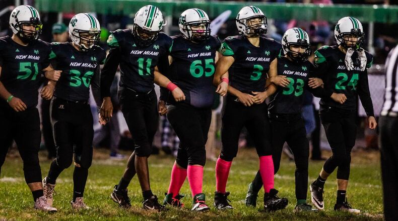 New Miami seniors lock arms as they make their way out for the coin toss before their game against Cincinnati Country Day Friday, Oct. 25, 2019 at New Miami High School. New Miami defeated Cincinnati Country Day 34-6 and is 9-0 for the first time in school history. NICK GRAHAM/STAFF